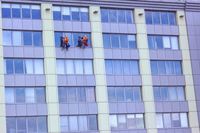 两个工人高空作业工人洗摩天大楼窗户