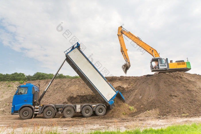 卡车和挖掘机在一起构建声音障碍沙子