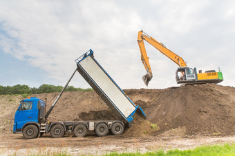 卡车和挖掘机在一起构建声音障碍沙子