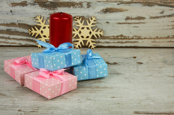 圣诞节装饰与四个圣诞节礼物红色的蜡烛和两个木装饰雪花古董背景关闭水平视图