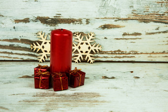 四个小装饰礼物红色的纸红色的蜡烛和两个装饰木雪花的背景的老木背景水平视图
