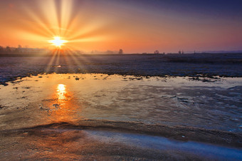 日出在冻字段和的反射的太阳的冰覆盖的菲尔德波尔斯卡的结束februaryhorizontal视图