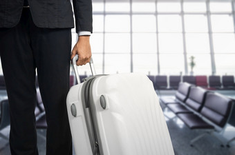 商人和手提箱的机场离开休息室飞机的模糊背景夏天假期概念旅行者手提箱机场终端等待区域商人和手提箱