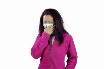 女人与流感打喷嚏女人穿着粉红色的冬天服装穿面具她的鼻子冷和流感健康概念孤立的白色背景女人穿流感面具