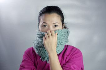 女人穿粉红色的衣服冬天服装有围巾从她的鼻子的概念健康的冷空气女人冬天