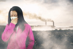 女人与流感打喷嚏女人穿着粉红色的冬天服装穿面具她的鼻子冷和流感健康概念对空气污染背景空气污染