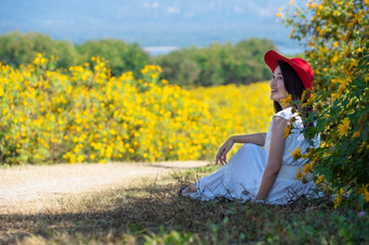 美丽的女人自然花她的穿白色礼服和红色的他坐着东没听见舌墨西哥向日葵场美卫生部煤炭我的lampang省泰国美丽的女人自然花