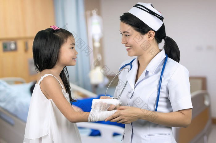 亚洲护士统一的儿科哪女孩与背景模糊病人房间亚洲护士
