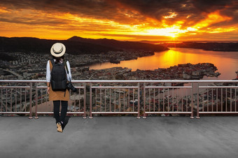 亚洲女游客她穿休闲风格日本与简单的黑色的背包和相机与镜头后面看景观视图冬天挪威亚洲女游客冬天