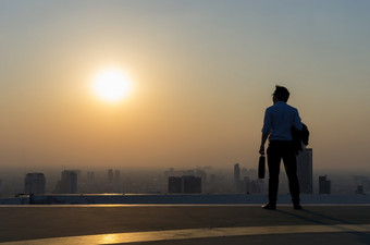 概念愿景年轻的商人穿舒适的<strong>休闲西装</strong>夹克站持有工作袋前的建筑和看在高现代建筑城市景观天际线愿景业务愿景业务