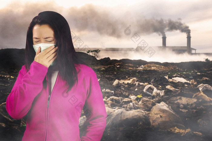女人与流感打喷嚏女人穿着粉红色的冬天服装穿面具她的鼻子冷和流感健康概念对空气污染背景空气污染