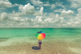 亚洲女人和色彩斑斓的<strong>雨伞</strong>站的海滩蓝色的天空女人和色彩斑斓的<strong>雨伞</strong>