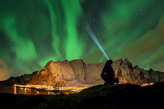 游客是看的极光北欧化工极地灯在奥尔斯汀登令人惊异的位岩石位于关闭的村纯洁罗弗敦群岛岛屿挪威极光北欧化工在奥尔斯汀登