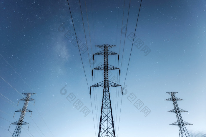 高电压电桥塔和传输权力行和部分电设备和高电压权力行绝缘体晚上与乳白色的道路蓝色的语气高电压电桥塔晚上