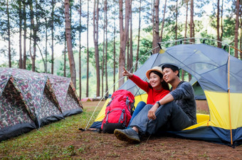 快乐夫妇野营的自然和指出的某个地方黄色的帐篷下美丽的松森林庞oung美在香港儿子泰国夫妇野营