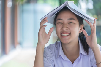 年轻的亚洲大学学生统一的美丽的女孩放松和微笑读书与放松情绪咖啡商店为学习在线休闲业务社会会议教育概念教育概念
