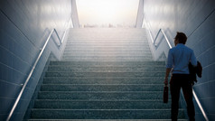 商人爬上的楼梯会的城市野心概念和成功业务成成功