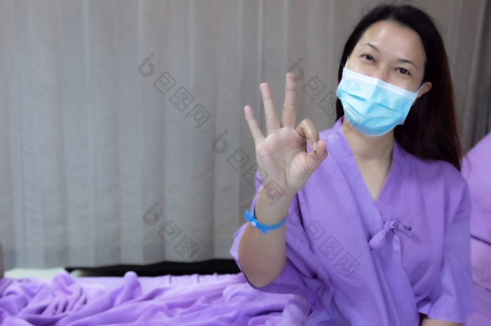 年轻的亚洲女病人微笑和显示手势病人感觉快乐和舒适的与治疗和治疗医院床上医院房间医疗医疗保健概念医疗医疗保健概念