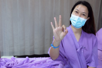 年轻的亚洲女病人微笑和显示手势病人感觉快乐和舒适的与治疗和治疗医院床上医院房间<strong>医疗医疗</strong>保健概念<strong>医疗医疗</strong>保健概念