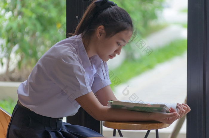 年轻的亚洲大学学生统一的美丽的女孩放松和微笑读书与放松情绪咖啡商店为学习在线休闲业务社会会议教育概念教育概念