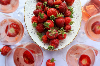 有创意的作文与玫瑰酒和美味的草莓的白色背景前视图有创意的作文与玫瑰酒和美味的草莓的白色背景前视图