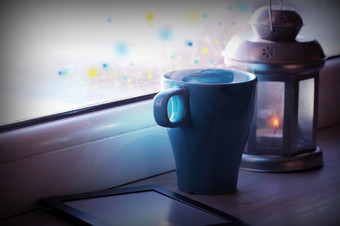 冬天装饰与灯笼热茶杯电子书读者和灯窗口冬天装饰与灯笼热茶杯电子书读者和灯窗口