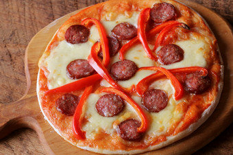 热自制的披萨与意大利辣香肠paprica木表格前视图热自制的披萨与意大利辣香肠paprica木表格前视图
