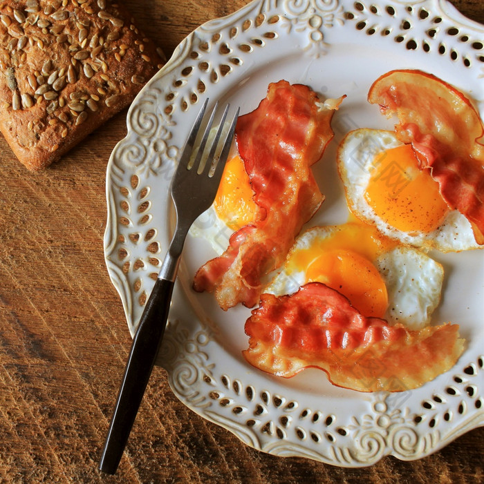 早餐脆皮培根炸鸡蛋和面包三明治白色板乡村表格前视图早餐脆皮培根炸鸡蛋和面包三明治白色板乡村表格前视图