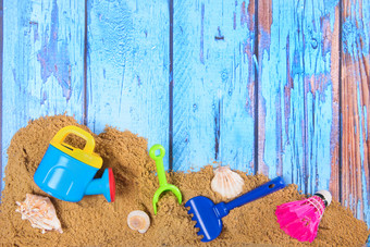 海滩海报木背景与沙子和塑料玩具