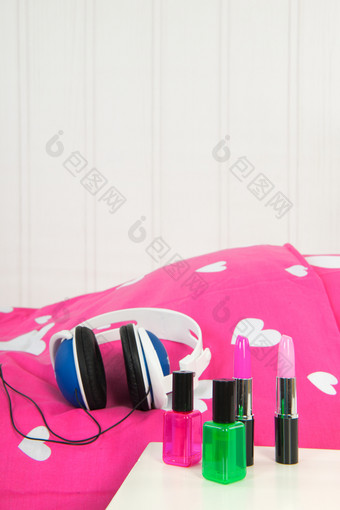 头手机和化妆铺设粉红色的床上