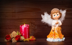 圣诞节问候卡与蜡烛和天使木背景