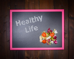 的图片黑板上的左一边与写健康的生活和的正确的一边沙拉蔬菜木背景