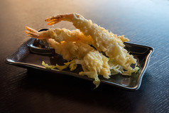 日本厨房天妇罗虾深炸虾与酱汁和蔬菜黑色的板