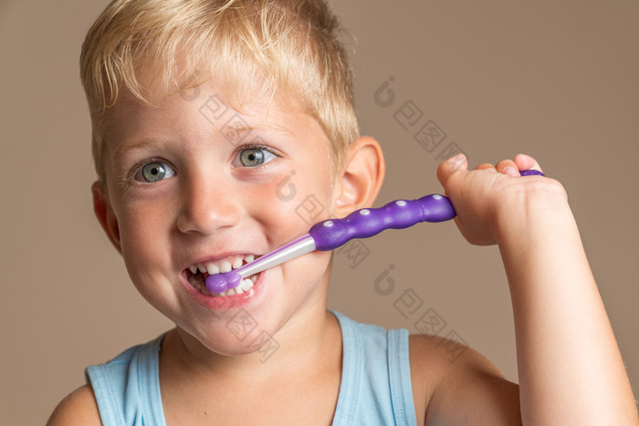 小婴儿男孩与牙刷孩子男孩微笑幸福牙科卫生和健康为孩子们棕色（的）背景