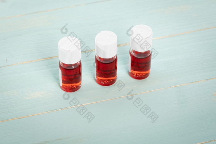 三个医学瓶填满与红色的液体安排行绿色木