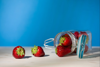 草莓和玻璃Jar完整的草莓说谎下来表格与蓝色的背景草莓和玻璃Jar完整的草莓说谎下来表格