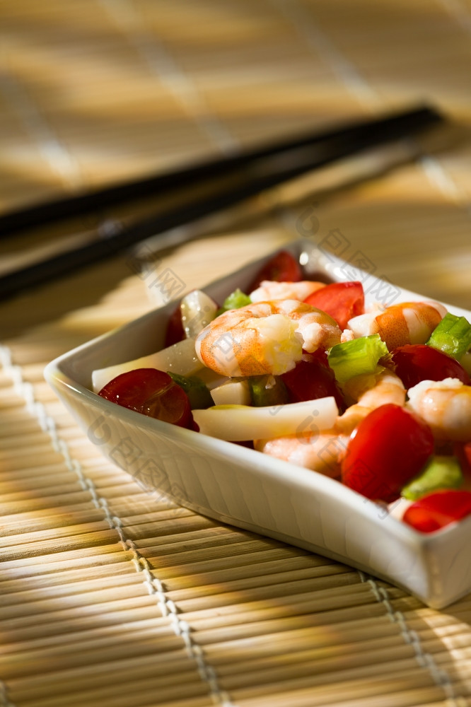 虾沙拉与鱿鱼西红柿芹菜内部白色碗竹子桌布和筷子虾沙拉竹子桌布和筷子