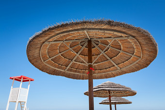 生活警卫站和三个海滩<strong>雨伞</strong>蓝色的天空背景生活警卫站和三个海滩<strong>雨伞</strong>