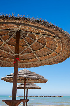 三个海滩雨伞蓝色的天空背景三个海滩雨伞