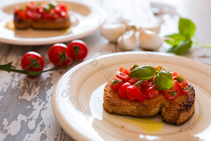 特写镜头意大利意式烤面包片与番茄和罗勒在老表格特写镜头意大利意式烤面包片与番茄和罗勒