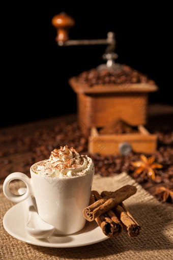 咖啡杯与生奶油和可可粉和咖啡磨床背景咖啡杯与生奶油和咖啡磨床背景
