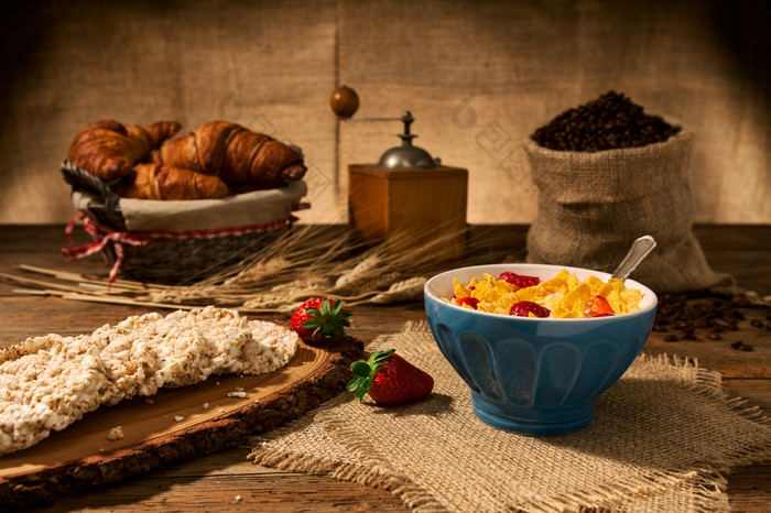 大陆早餐与玉米片和草莓杯牛奶和大米饼干在老木表格大陆早餐与玉米片和草莓杯牛奶和大米饼干