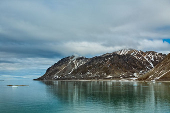 多云的天空和山沿着的马格达莱纳峡湾斯瓦尔巴特群岛岛屿挪威马格达莱纳峡湾斯瓦尔巴特群岛岛屿挪威