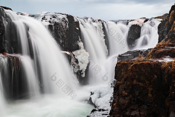 特写镜头煤猫头鹰猫头鹰瀑布冰岛多云的一天煤猫头鹰猫头鹰瀑布冰岛