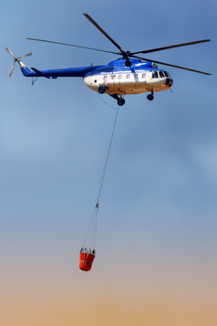 蓝色的火救援直升机与水桶运输