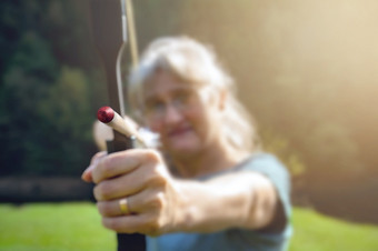 女人与灰色的头发的<strong>目标</strong>与弓和箭头自然和太阳概念为的战斗达到的<strong>目标</strong>