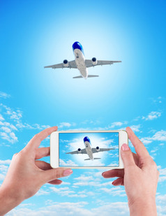 女手持有使用移动电话和飞机蓝色的背景女手持有使用移动电话和飞机蓝色的