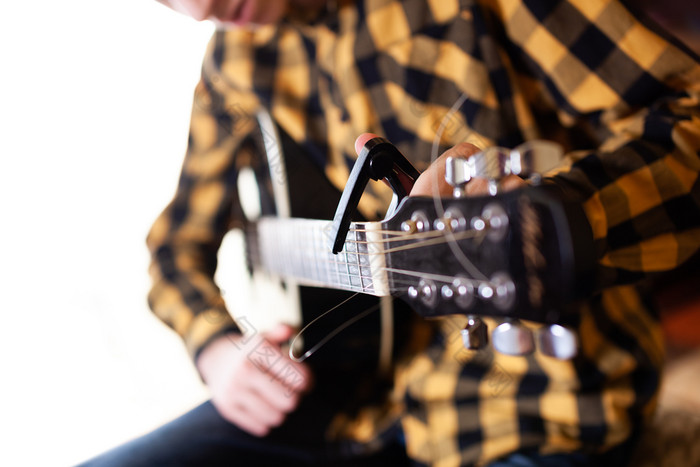 安装capodaster也被称为投诉 警察 课为吉他把在的字符串特写镜头