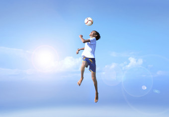 运动模糊拍摄年轻的男孩跳足球球员做令人惊异的使中用背景蓝色的天空快乐快乐好情绪