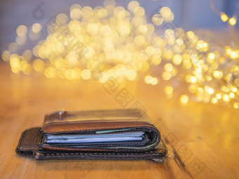 钱包和移动封面皮革木表格与小装修光散景背景